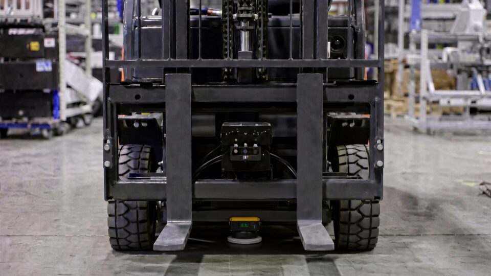 front view of an empty AGV forklift with camera and safety scanner between the forks; user-provided case image